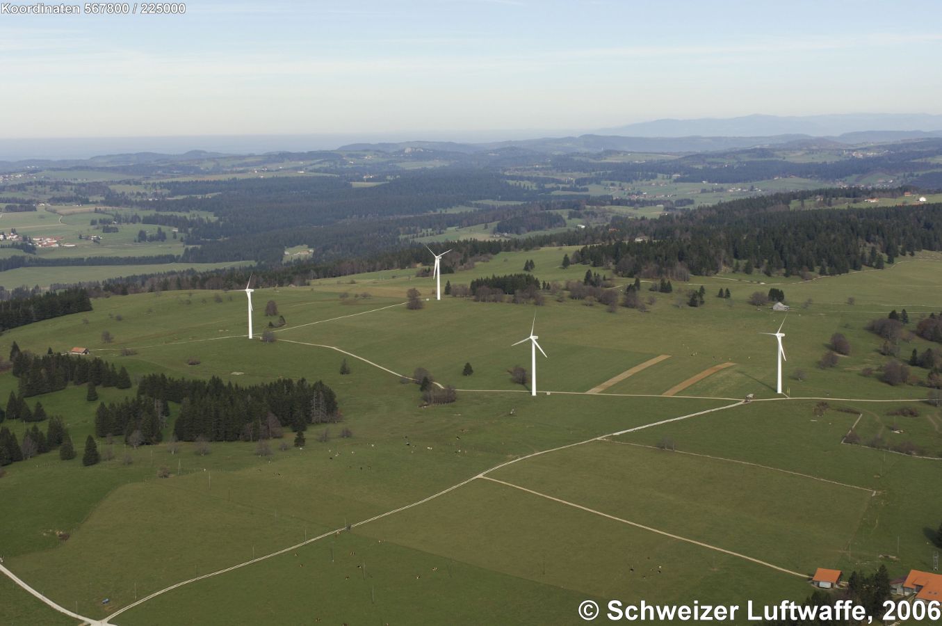 Mont Crosin: Centrale éolienne (Position: 2'567'886.23, 1'225'155.28), liegen auf der Montagne du Droit. und auf die Franches Montagnes im Hintergrund. Norden: linke obere Bildecke.